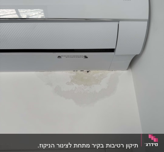מזגן על קיר עם סימני רטיבות מתחתיו